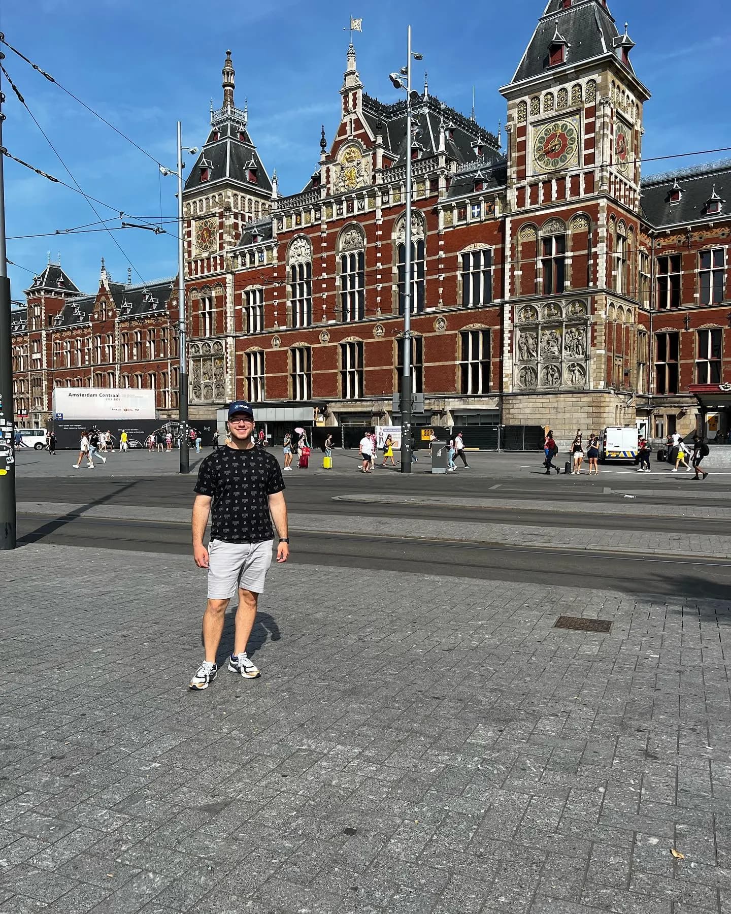 Tyler Henn standing in front of Amsterdam Centraal station in Amsterdam, Netherlands