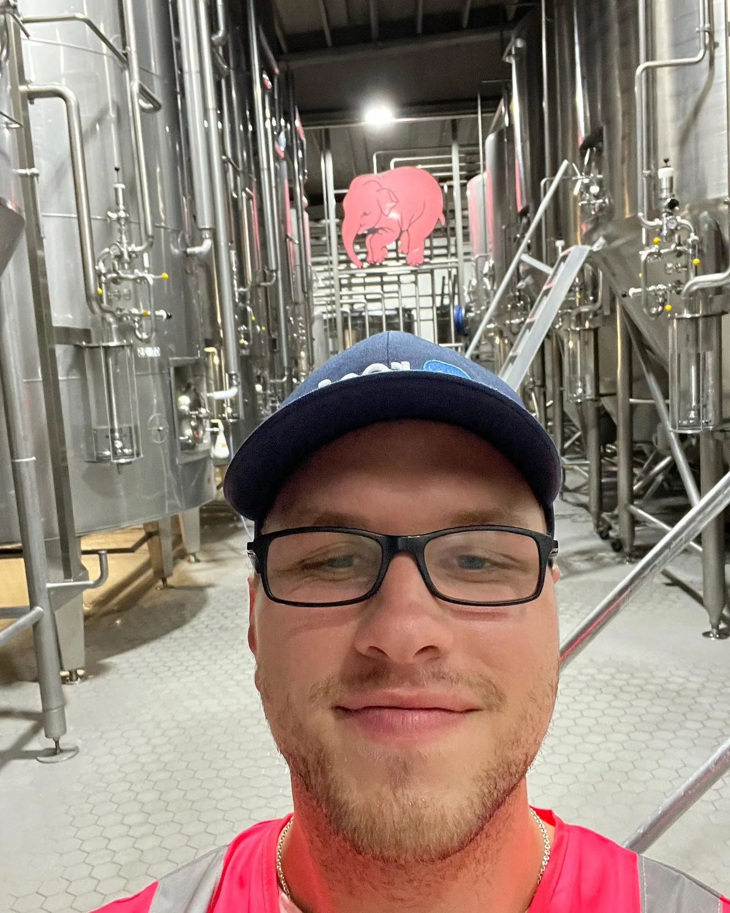 Tyler Henn taking a selfie between brewing tanks at Delirium Brewery in Melle, Belgium