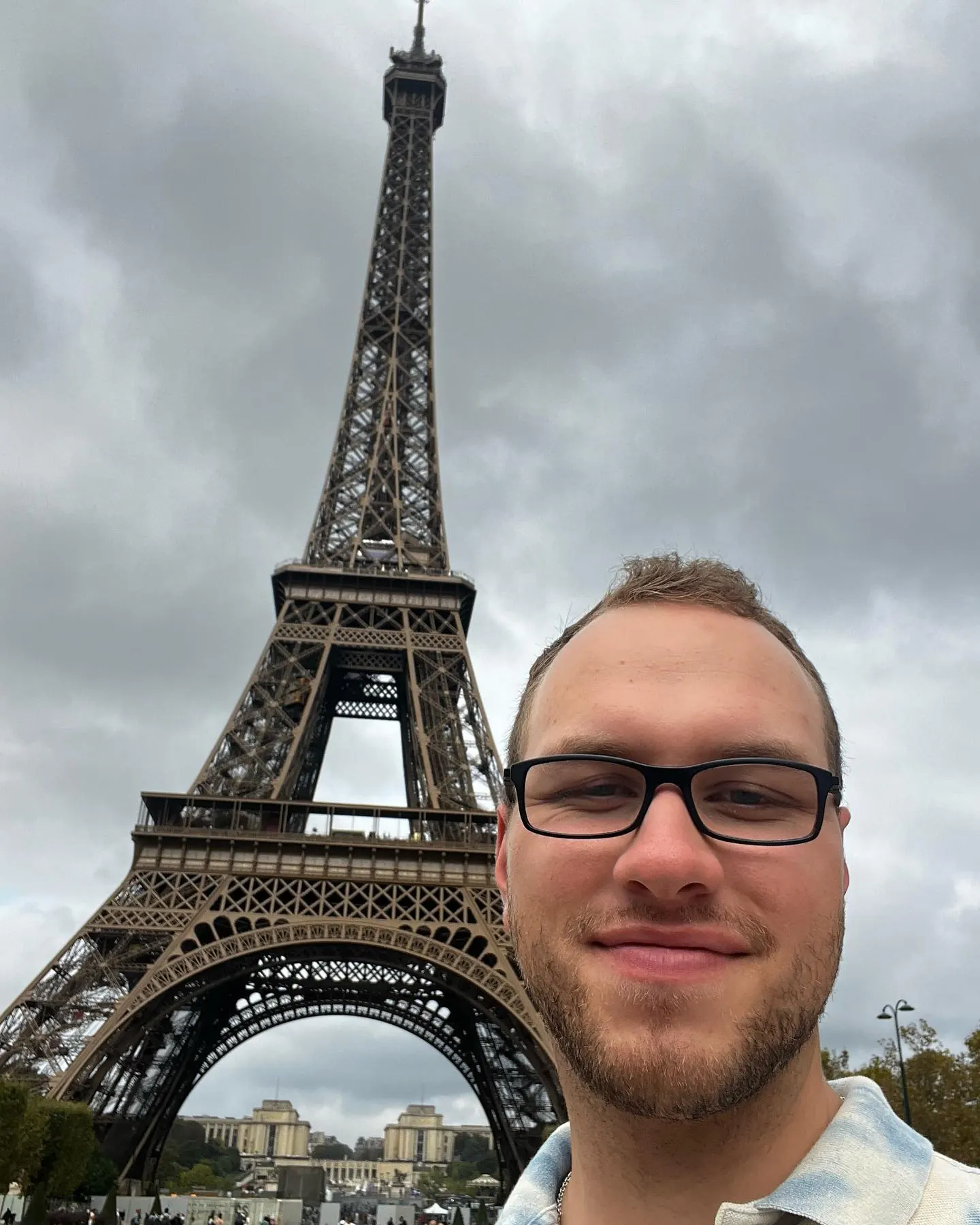 Tyler Henn taking a selfie in front of the Eiffel Tower in Paris, France