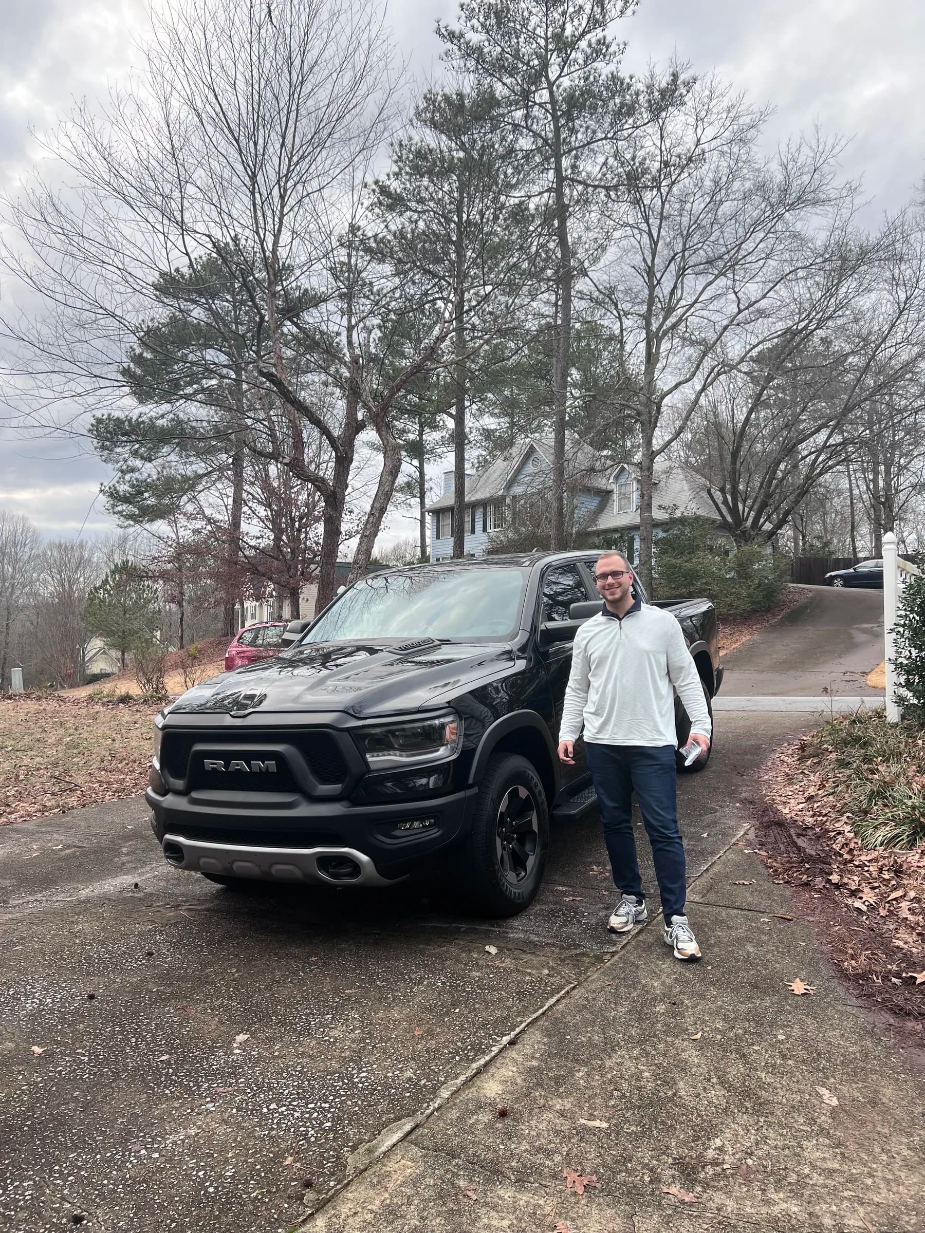 Tyler Henn standing outdoors beside a black RAM pickup truck