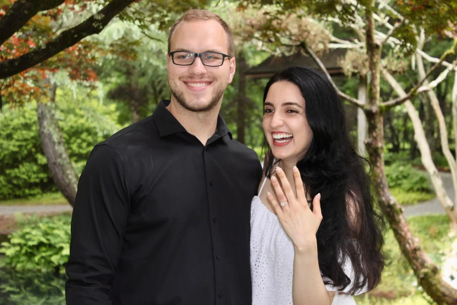 Tyler Henn posing with a woman in an outdoor engagement portrait