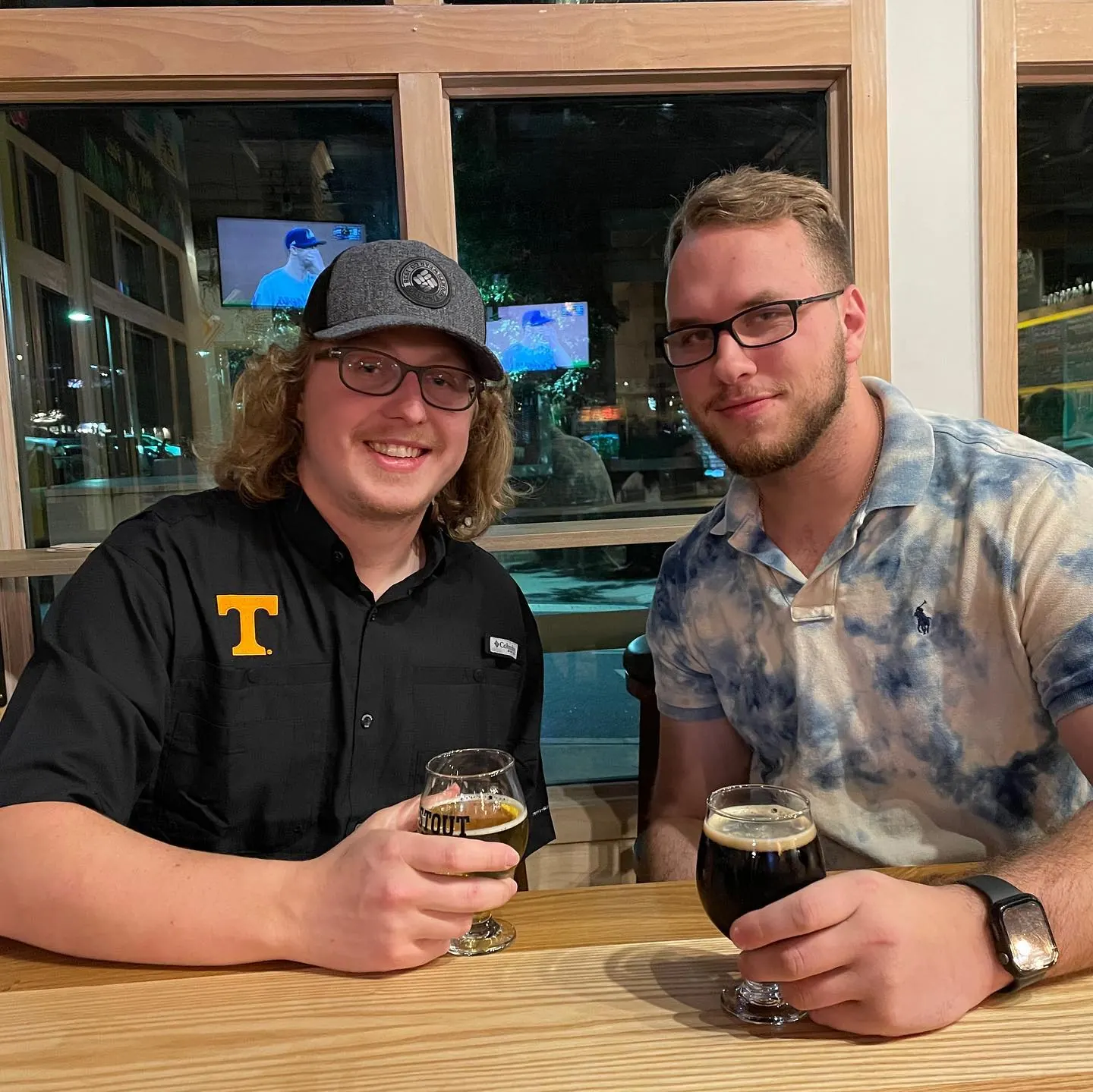 Tyler Henn and a friend sharing drinks together at a table