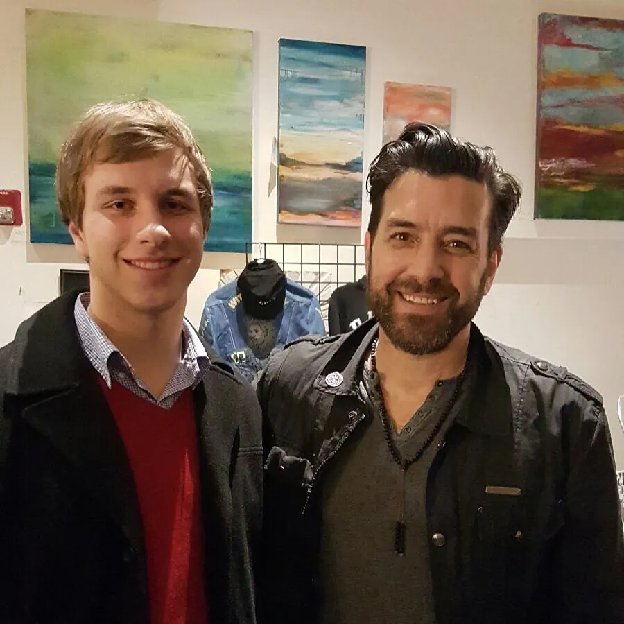 Tyler Henn posing with musician Bob Schneider at a live music show