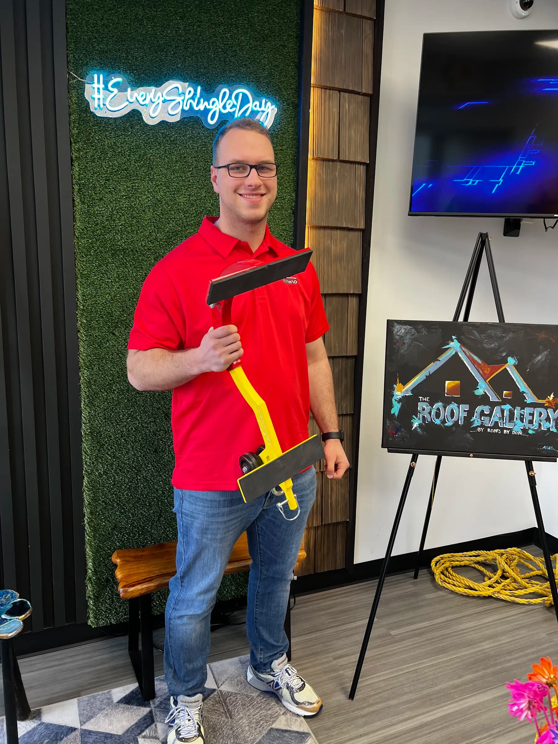 Tyler Henn holding a roofing tool at The Roof Gallery by Roofs by Don